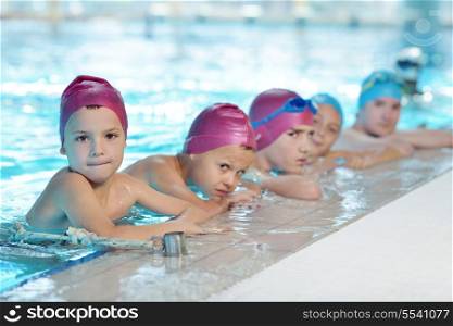 happy children kids group at swimming pool class learning to swim