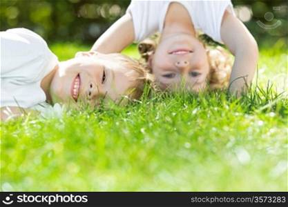 Happy children playing on green grass in spring park. Environment protection concept
