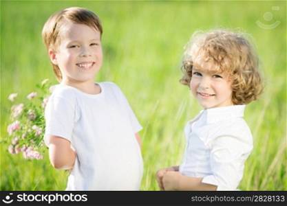 Happy children with flowers in spring field