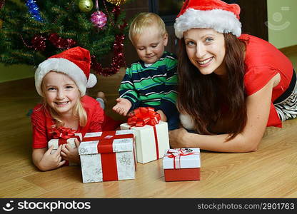 happy children with mother near Christmas tree