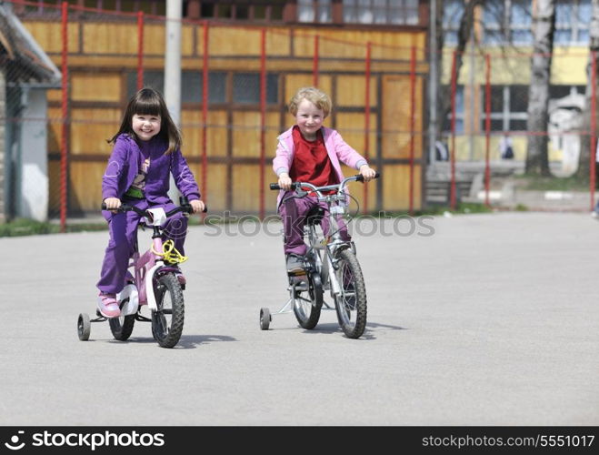 happy childrens group learning to drive bicycle outdoor at beautiful sunny spring day