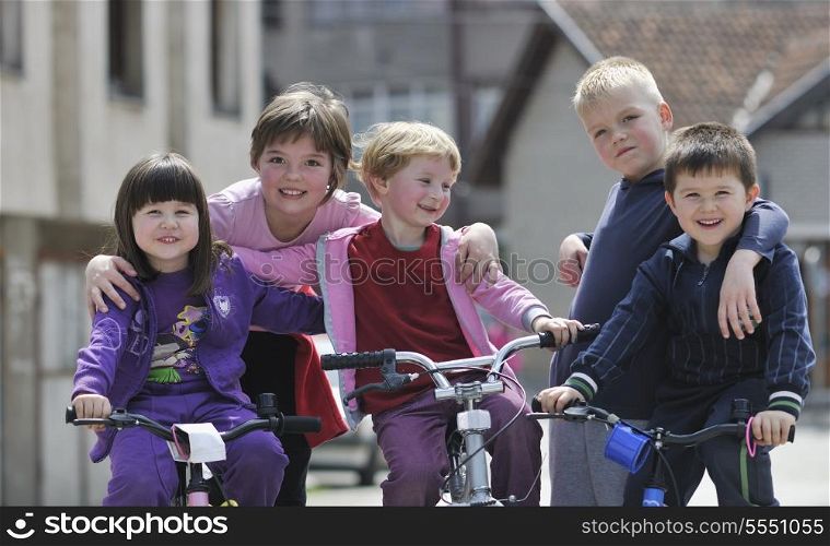 happy childrens group learning to drive bicycle outdoor at beautiful sunny spring day