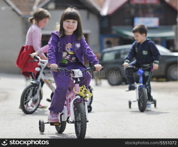 happy childrens group learning to drive bicycle outdoor at beautiful sunny spring day