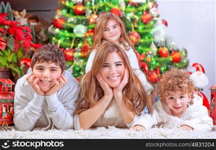 Happy Christmas celebration, cheerful family having fun at home, lying down near beautiful decorated Christmas tree, love and happiness concept