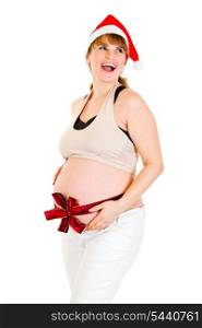 Happy christmas pregnant woman in Santa hat with red ribbon on belly isolated on white &#xA;