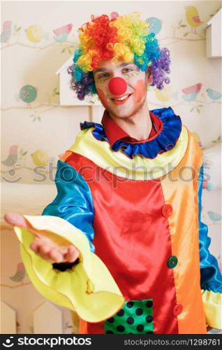 Happy clown with red nose and colourful costume offers friendship.