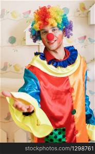 Happy clown with red nose and colourful costume offers friendship.