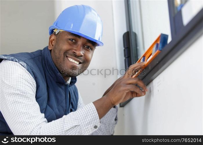 happy construction worker using bubble level