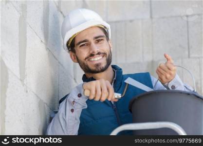 happy contractor employee applying plaster on wall