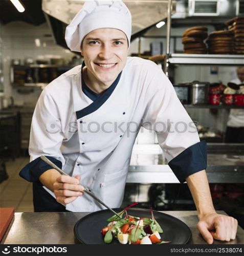 happy cook putting spinach plate with salad