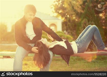 Happy couple against the background of autumn park, backlit composition, togetherness concept, love and tenderness