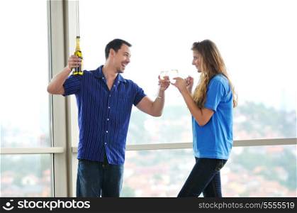 happy couple at big bright comfort apartment celebrate with glasses of champagne