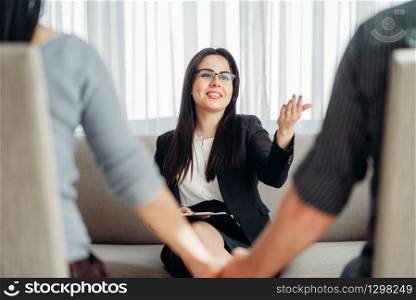 Happy couple at psychologist, family psychology support, civilized solution to the problem. Female doctor helps patients with consultation. Happy couple at psychologist, family psychology