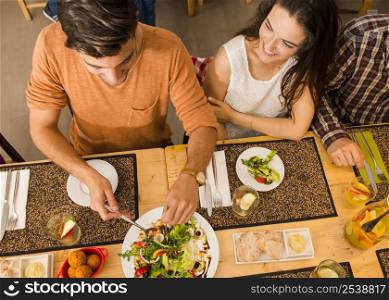 Happy couple at the restaurant and being served of food in the plate