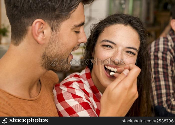 Happy couple at the restaurant and giving food in mouth