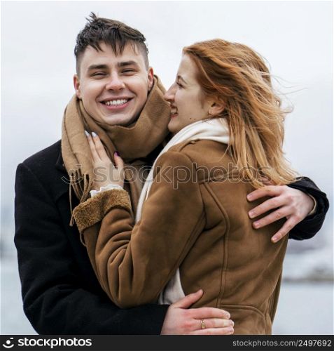 happy couple by lake during winter