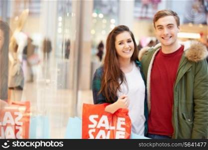 Happy Couple Carrying Bags In Shopping Mall