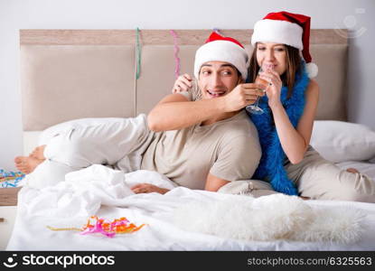 Happy couple celebrating christmas holiday in bed