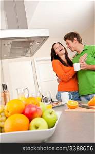 Happy couple drinking coffee in modern kitchen together