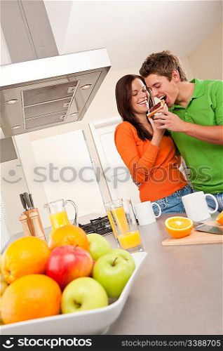 Happy couple drinking coffee in the kitchen together