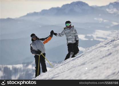 happy couple drivingand relaxing with snowboard and ski at winter seasson on mountain