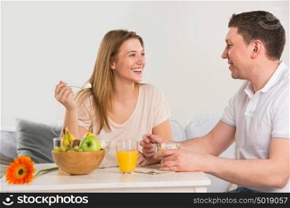 Happy couple eating at home - having breakfast together