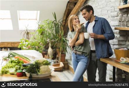 Happy couple eating breakfast together in the rustic kitchen at home