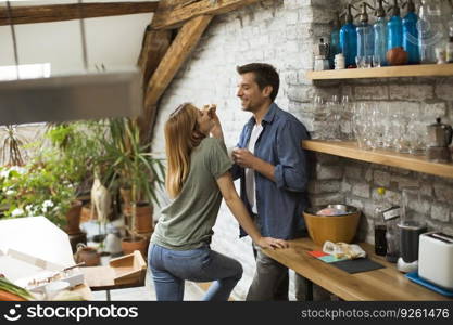 Happy couple eating breakfast together in the rustic kitchen at home