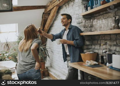 Happy couple eating breakfast together in the rustic kitchen at home