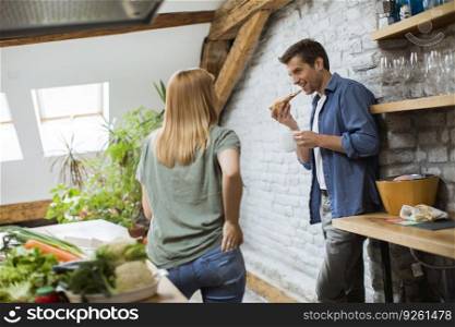 Happy couple eating breakfast together in the rustic kitchen at home