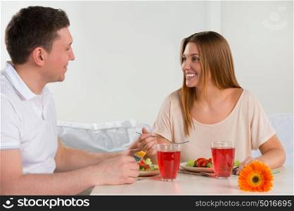 Happy couple eating vegetable salad at home - having breakfast or lunch