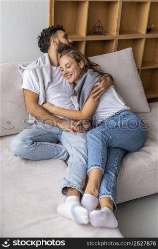 happy couple embraced sofa home