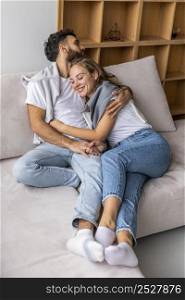 happy couple embraced sofa home
