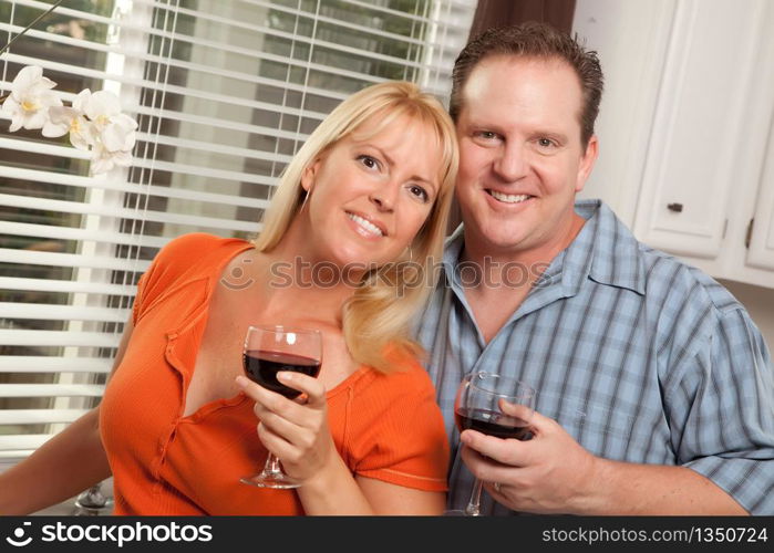 Happy Couple Enjoying a Glass of Wine the Kitchen.