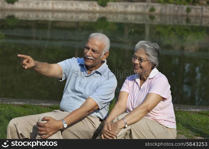 Happy couple enjoying at park , man pointing at something interesting