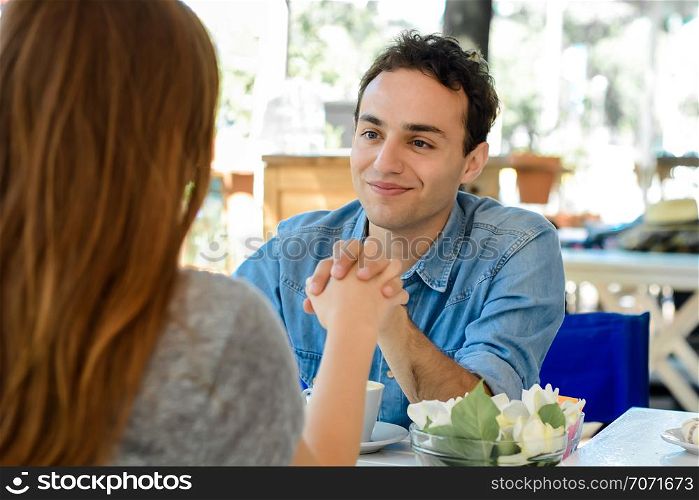 Happy couple enjoying breakfast in a cafe. Love and lifestyle concept.