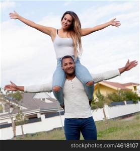 Happy couple enjoying flying on the street, female on man's back