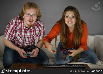 Happy couple enjoying leisure time by playing video games together. Studio shot. Gaming couple playing games