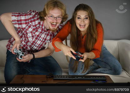 Happy couple enjoying leisure time by playing video games together. Studio shot. Gaming couple playing games