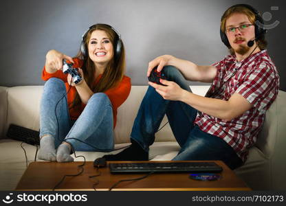 Happy couple enjoying leisure time by playing video games together. Studio shot. Gaming couple playing games