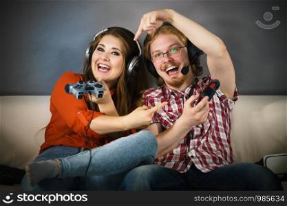 Happy couple enjoying leisure time by playing video games together. Studio shot. Gaming couple playing games