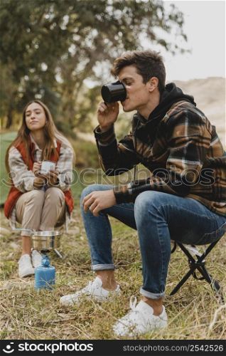 happy couple forest drinking coffee
