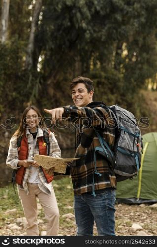 happy couple forest holding map pointing