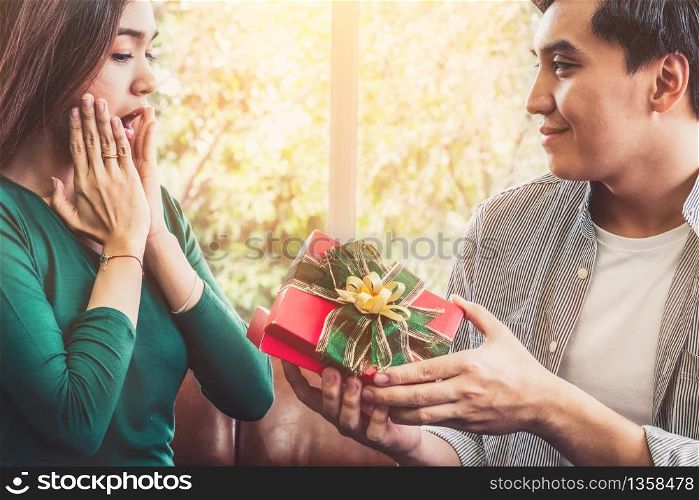 Happy couple giving gift present to celebrate anniversary. Marriage lifestyle, love and relationship concept.