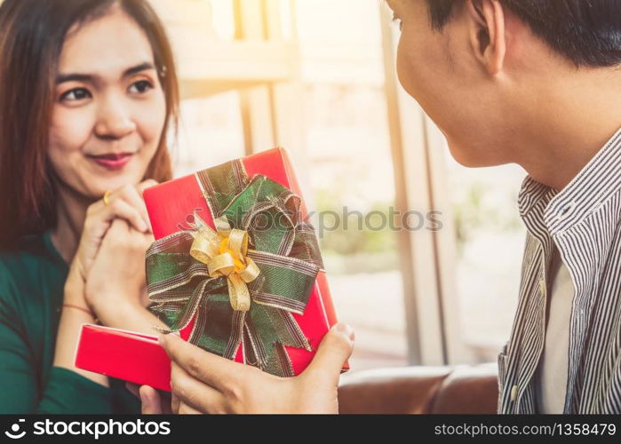 Happy couple giving gift present to celebrate anniversary. Marriage lifestyle, love and relationship concept.