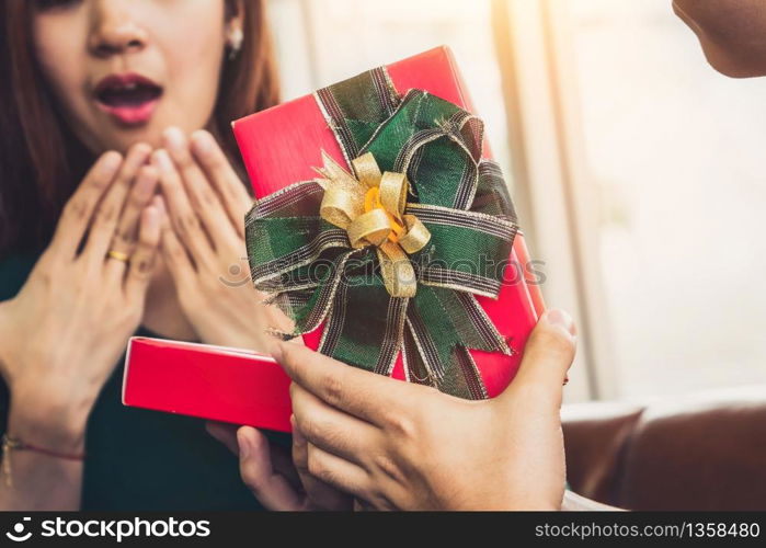 Happy couple giving gift present to celebrate anniversary. Marriage lifestyle, love and relationship concept.