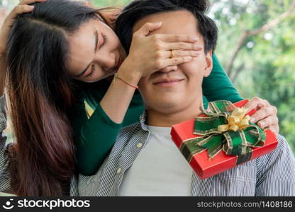 Happy couple giving gift present to celebrate anniversary. Marriage lifestyle, love and relationship concept.