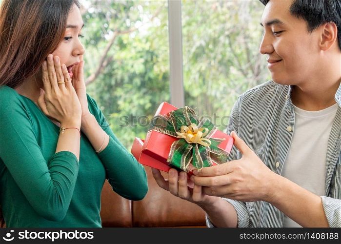 Happy couple giving gift present to celebrate anniversary. Marriage lifestyle, love and relationship concept.
