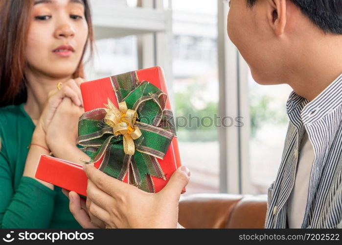 Happy couple giving gift present to celebrate anniversary. Marriage lifestyle, love and relationship concept.