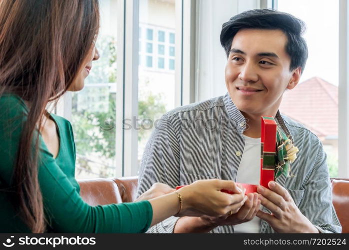 Happy couple giving gift present to celebrate anniversary. Marriage lifestyle, love and relationship concept.